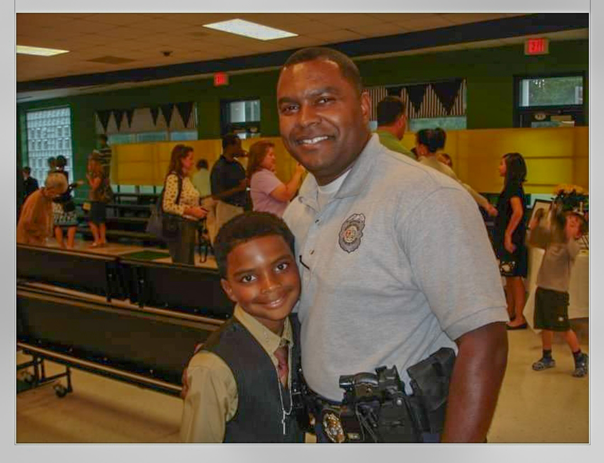 Major Catoe standing with son in school